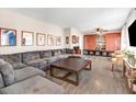 Spacious living room featuring plush gray sectional, hardwood floors, built in cabinets, and large windows at 104 Amberhill Ct, Garner, NC 27529
