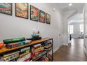 Hallway features a wooden shelving unit filled with board games and modern art pieces at 117 Highland Forest Dr, Fuquay Varina, NC 27526