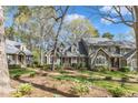 View of gray home with dormer windows, brick walkway, and lush green lawn and landscaping at 131 Long Shadow Ln, Cary, NC 27518