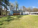 Inviting blue house with a well-manicured lawn, a single car garage, and a large carport at 1402 Valley Rd, Garner, NC 27529