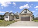Inviting two-story home with stone details, a two-car garage, and a meticulously kept lawn at 151 S Harper Faith Way, Benson, NC 27504