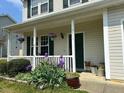 Inviting front porch with beautiful landscaping including hanging plants and potted flowers at 1643 Southcross St, Fuquay Varina, NC 27526