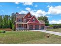 Attractive two-story home with a three-car garage and a lush green lawn at 182 Prince Place Dr, Fuquay Varina, NC 27526