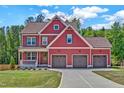 Beautiful two-story home featuring a three-car garage and a well-manicured lawn at 182 Prince Place Dr, Fuquay Varina, NC 27526