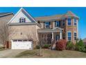 Inviting exterior showcasing a brick facade, two-car garage, manicured lawn, and covered front porch at 1950 Firenza Dr, Apex, NC 27502