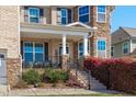 Charming front porch with stone accents, wrought iron railing, and colorful landscaping at 1950 Firenza Dr, Apex, NC 27502