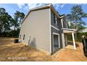 Side view of a gray two-story house featuring low-maintenance vinyl siding and an attached open garage at 205 Regis Ln # 11, Coats, NC 27521