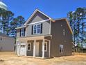 A two-story home with gray siding, black shutters, and a covered front porch is shown at 205 Regis Ln # 11, Coats, NC 27521