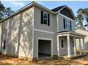 Two-story home with gray siding and an attached, open garage providing ample space for vehicles and storage at 205 Regis Ln # 11, Coats, NC 27521