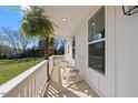 Relaxing porch with white rocking chairs, matching white trim, and wood posts at 2142 Henderson Tanyard Rd, Pittsboro, NC 27312