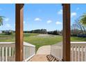 Open-air view from a porch showing manicured land and a large equestrian arena on a sunny day at 2142 Henderson Tanyard Rd, Pittsboro, NC 27312