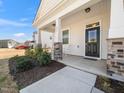 Inviting front porch with stone pillars, rocking chairs, and stylish front door at 217 Mallard Loop Dr, Clayton, NC 27527