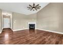 Cozy living room featuring a fireplace, hardwood floors, and a ceiling fan at 220 Shawnee Dr, Louisburg, NC 27549