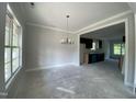 Dining room with elegant chandelier and view of the kitchen, perfect for entertaining guests at 226 Rolling Pasture Way, Sanford, NC 27332