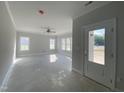 Bright and spacious living room with large windows, ceiling fan, and a door leading to the backyard at 226 Rolling Pasture Way, Sanford, NC 27332