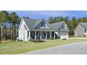 Charming home with a covered front porch, manicured lawn, and an American flag at 236 Star Valley Dr, Angier, NC 27501
