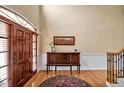Bright foyer boasts a wood front door, high ceilings, wood floors, and a decorative table with art at 2550 Bittersweet Dr, Durham, NC 27705