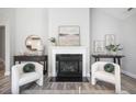 Cozy living room area featuring a fireplace, stylish decor, and views of the kitchen at 262 Cardovia Way, Wendell, NC 27591