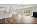 Spacious living area featuring hardwood floors, a fireplace, kitchen island and exterior French doors at 275 Cardovia Way, Wendell, NC 27591