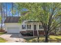 Lovely two-story home featuring a covered porch, a convenient attached garage, and a manicured lawn at 3 Guilder Cv, Durham, NC 27713