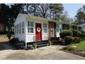 Inviting front porch features a red door, white sidelights and manicured landscaping at 3516 Apache Dr, Raleigh, NC 27609