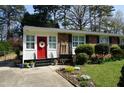 Charming brick home featuring a bright red door, white trim, and well-manicured front yard at 3516 Apache Dr, Raleigh, NC 27609