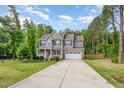 Beautiful two-story home with a long driveway and well-maintained lawn surrounded by lush trees at 40 Poplar Bark Dr, Youngsville, NC 27596