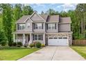 Charming two-story home featuring stone accents, manicured lawn and an attached two-car garage at 40 Poplar Bark Dr, Youngsville, NC 27596