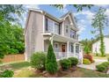 Two-story home showcasing the inviting front porch and decorative landscaping with shrubs and flowers at 40 Poplar Bark Dr, Youngsville, NC 27596