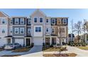 Attractive townhome with varying shades of gray, eye-catching windows, and neatly kept landscaping at 404 Deercroft Dr, Apex, NC 27539
