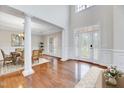 Bright foyer with hardwood floors, high ceilings, columns, and a charming double-door entrance at 404 Vintage Hill Cir, Apex, NC 27539