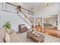 Bright living room boasts hardwood floors, grand staircase, and elegant columns at 404 Vintage Hill Cir, Apex, NC 27539