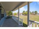 Covered front porch offering a relaxing outdoor space with views of the expansive lawn at 41 Rock Bluff Ln, Kittrell, NC 27544