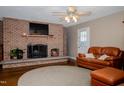 Cozy living room featuring a brick fireplace and leather couch with ottoman at 4105 Lassiter Rd, Wake Forest, NC 27587
