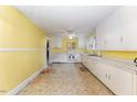 Spacious eat-in kitchen with ample cabinet space, neutral countertops, and vintage flooring at 413 S Maple St, Graham, NC 27253