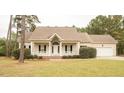 Inviting ranch home with a covered porch, attached garage, and well-maintained lawn at 45 Crabtree Ct, Fuquay Varina, NC 27526