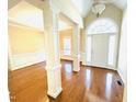 Bright foyer with gleaming hardwood floors, architectural columns, and modern lighting fixtures at 45 Crabtree Ct, Fuquay Varina, NC 27526