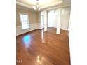 Spacious open-concept living room with gleaming hardwood floors and elegant architectural columns at 45 Crabtree Ct, Fuquay Varina, NC 27526