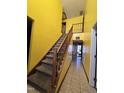 Bright yellow entryway with wood stairs and tile floors at 4610 Tyne Dr, Durham, NC 27703