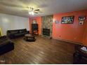Cozy living room with stone fireplace, ceiling fan, and dark wood flooring at 4610 Tyne Dr, Durham, NC 27703