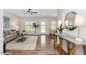 Open-concept living room with hardwood floors, neutral walls, dining area, and natural light at 50 Yelverton Ct, Holly Springs, NC 27540