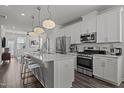 Modern kitchen featuring white cabinets, stainless steel appliances, and island with bar seating at 5200 Invention Way, Raleigh, NC 27616