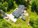 Expansive property featuring lush landscaping, a large driveway, a rear patio, and mature tree coverage at 5313 Edington Ln, Raleigh, NC 27604