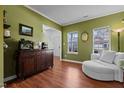 Inviting living area with green walls, white trim, hardwood floors, and comfortable seating at 5405 Seaspray Ln, Raleigh, NC 27610