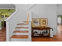 Elegant staircase featuring wood steps, white risers, and a classic banister with decor at 5405 Seaspray Ln, Raleigh, NC 27610