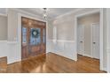 Foyer featuring a beautiful wooden front door, hardwood floors, and classic white trim at 5725 Lord Granville Way, Rolesville, NC 27571