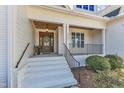 Inviting front porch with decorative columns, wood ceiling, and an elegant front door at 5725 Lord Granville Way, Rolesville, NC 27571