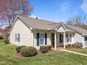 Well-maintained home featuring light yellow siding, blue shutters, and a lush green lawn at 6817 Fairpoint Ct, Raleigh, NC 27613
