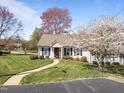 Landscaped front yard leads to a charming one-story home with blue shutters and a covered porch entry at 6817 Fairpoint Ct, Raleigh, NC 27613