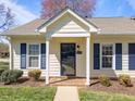 Inviting front entrance with a covered porch, dark front door, and manicured landscaping at 6817 Fairpoint Ct, Raleigh, NC 27613